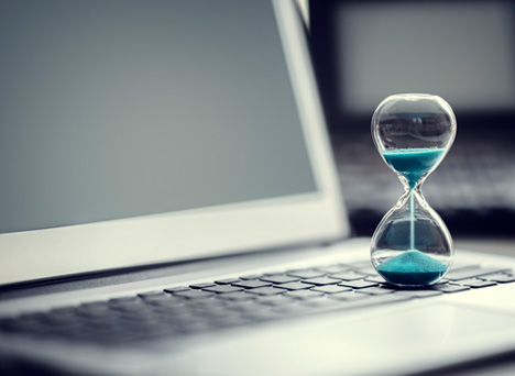 Timing The Sale of Your Business Glass Timer on Computer Image by Mergers and Acquisitions